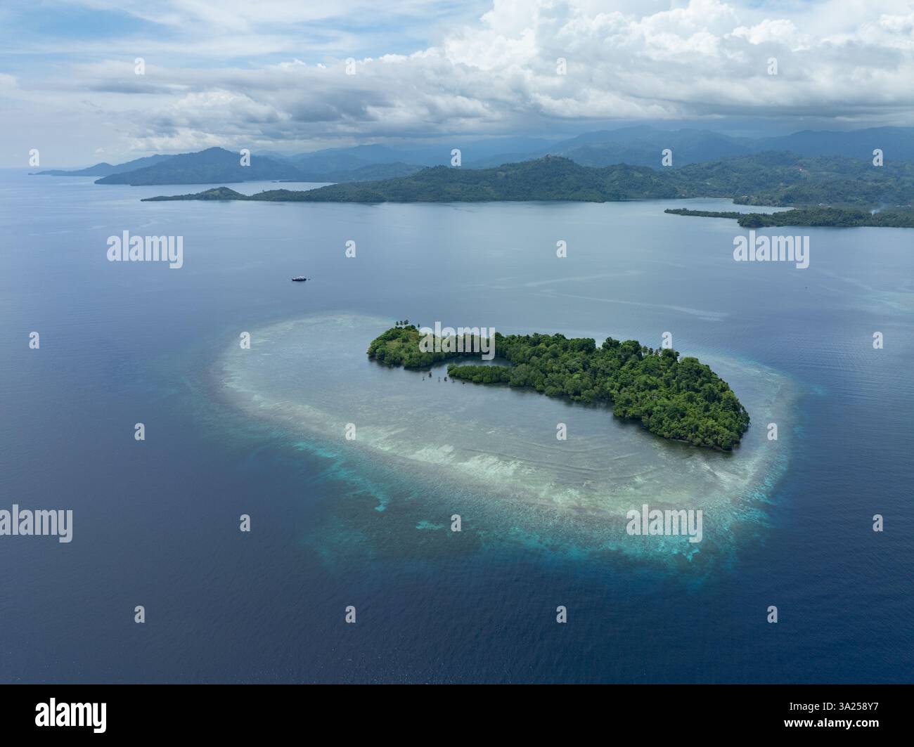 Une belle île est entourée par un récif corallien sain au large de la côte de Sulawesi Nord, Indonésie. Cette zone abrite une biodiversité marine élevée. Banque D'Images