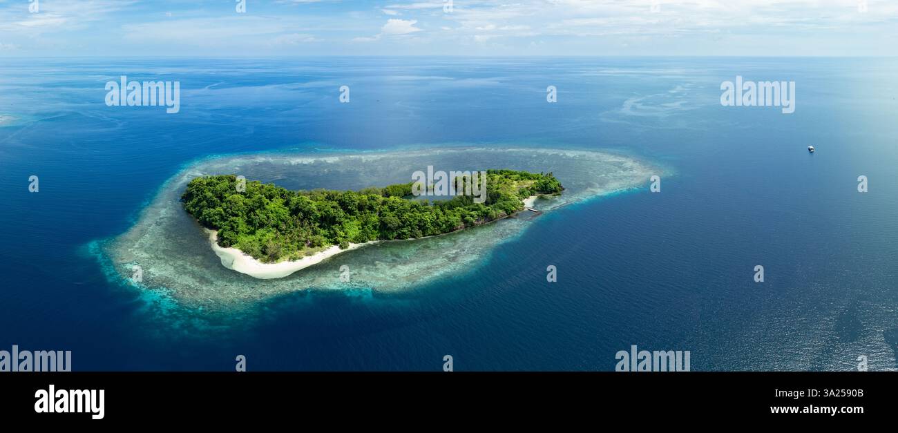 Une belle île est entourée par un récif corallien sain au large de la côte de Sulawesi Nord, Indonésie. Cette zone abrite une biodiversité marine élevée. Banque D'Images