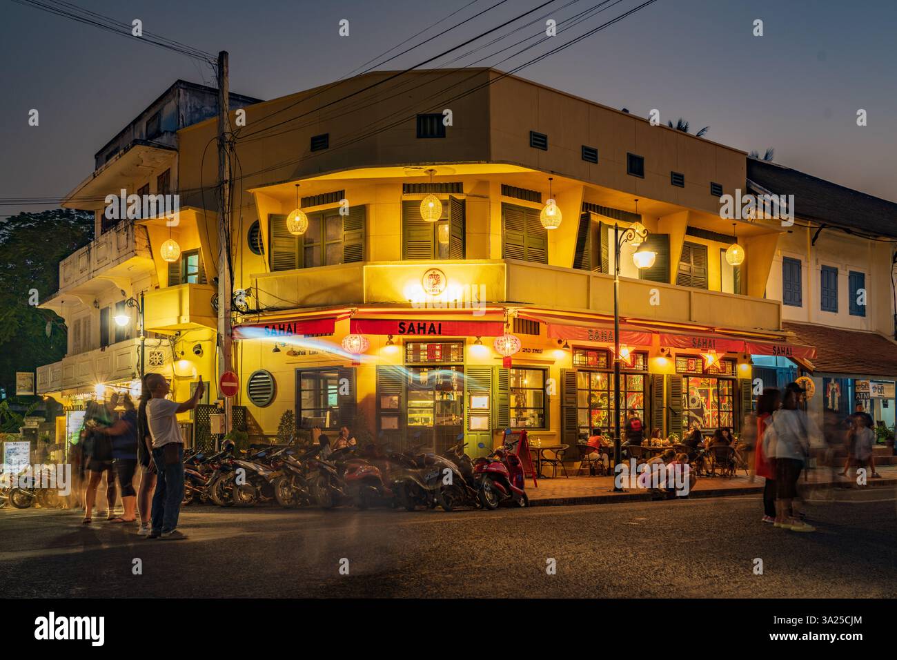 Charmante rue Luang Prabang au crépuscule, avec son architecture coloniale française, ses lumières chaudes et sa vie nocturne animée Banque D'Images