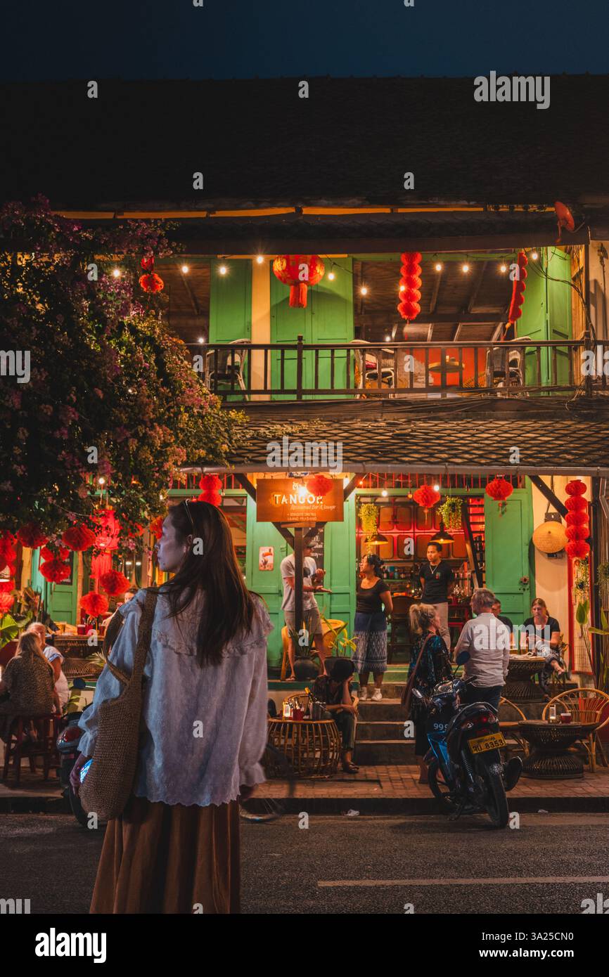 Charmante rue Luang Prabang au crépuscule, avec son architecture coloniale française, ses lumières chaudes et sa vie nocturne animée Banque D'Images