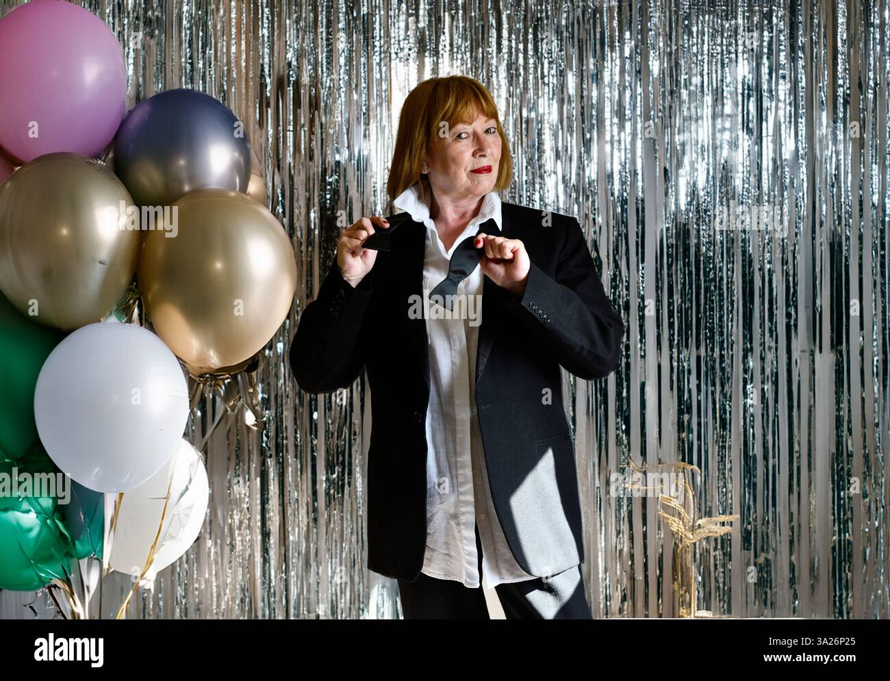 Dame portant costume de veste de dîner à cravate noire préparant pour une fête Banque D'Images