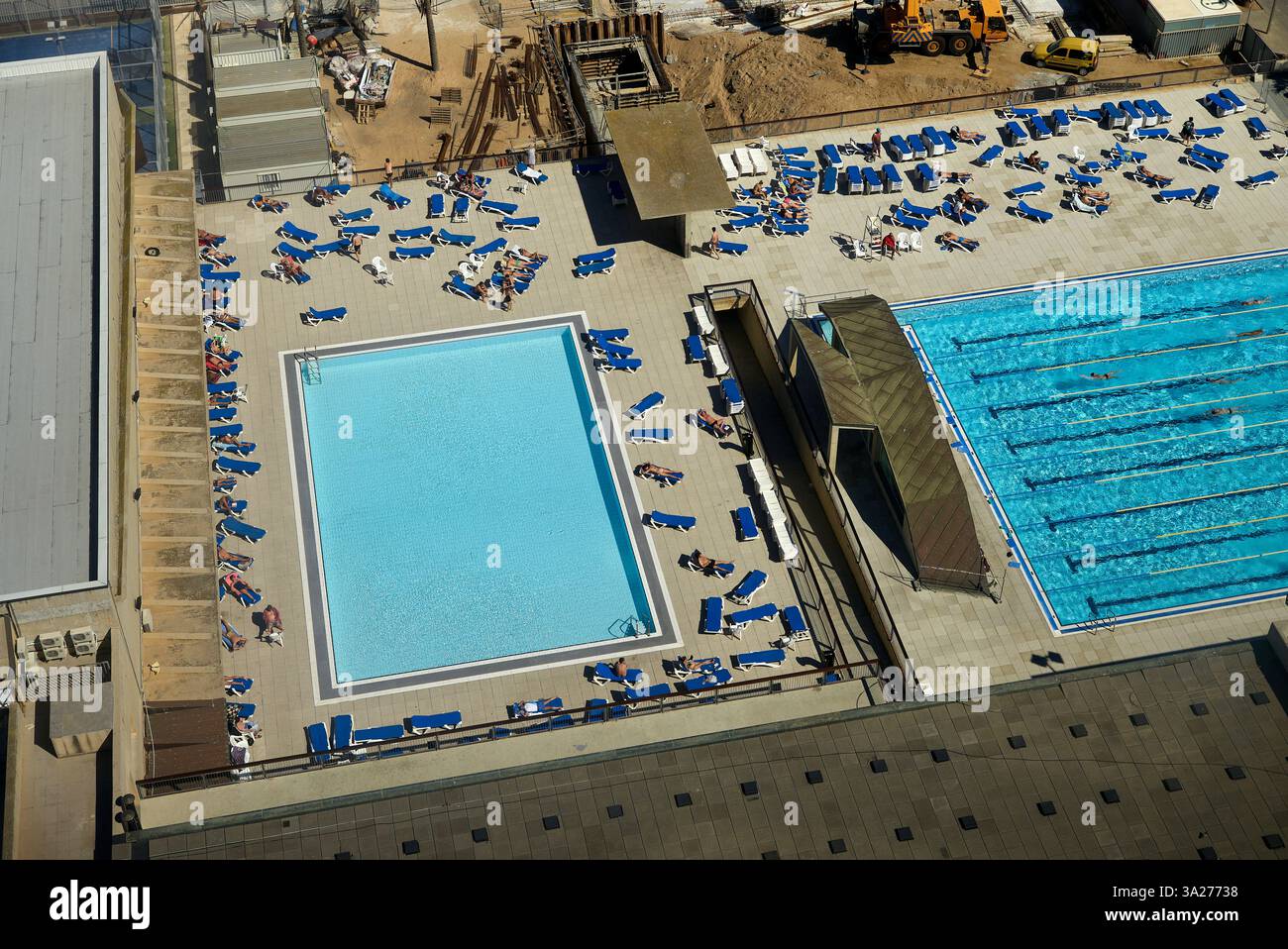 Vue aérienne de deux piscines extérieures avec bains de soleil et chaises longues les jours ensoleillés. Barcelone, Espagne Banque D'Images