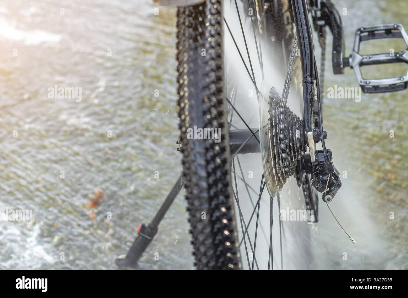 Laver un vélo dans un lave-auto avec un jet d'eau Banque D'Images