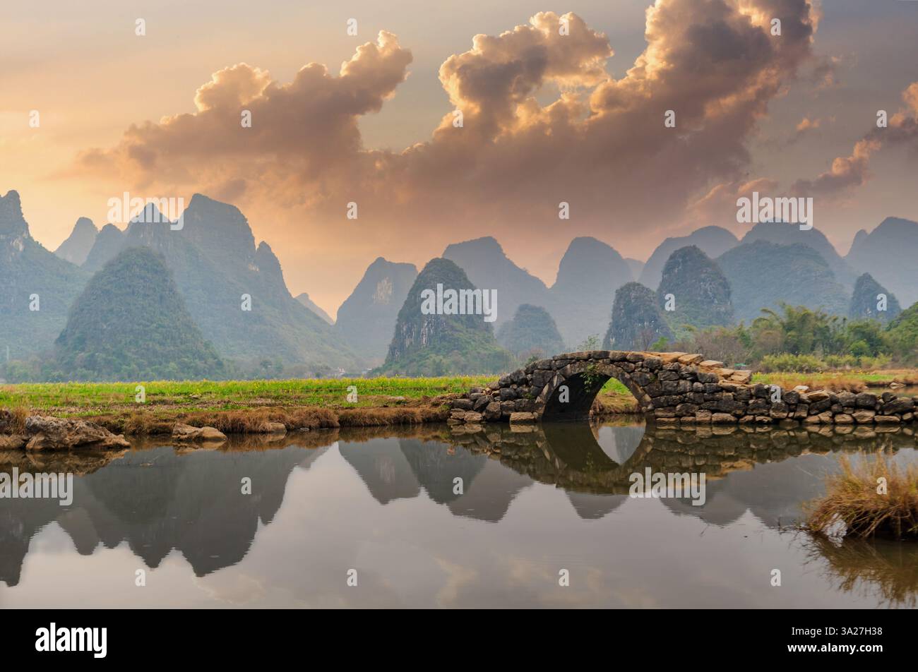 Montagnes Karst de Guilin et pont antique au coucher du soleil Banque D'Images Montagnes Karst de Guilin et pont antique au coucher du soleil Banque D'Images