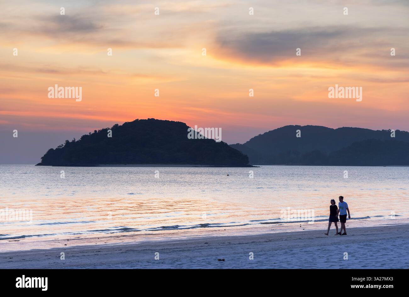 Couple marchant sur Cenang Beach au coucher du soleil, Langkawi, Kedah, Malaisie Banque D'Images