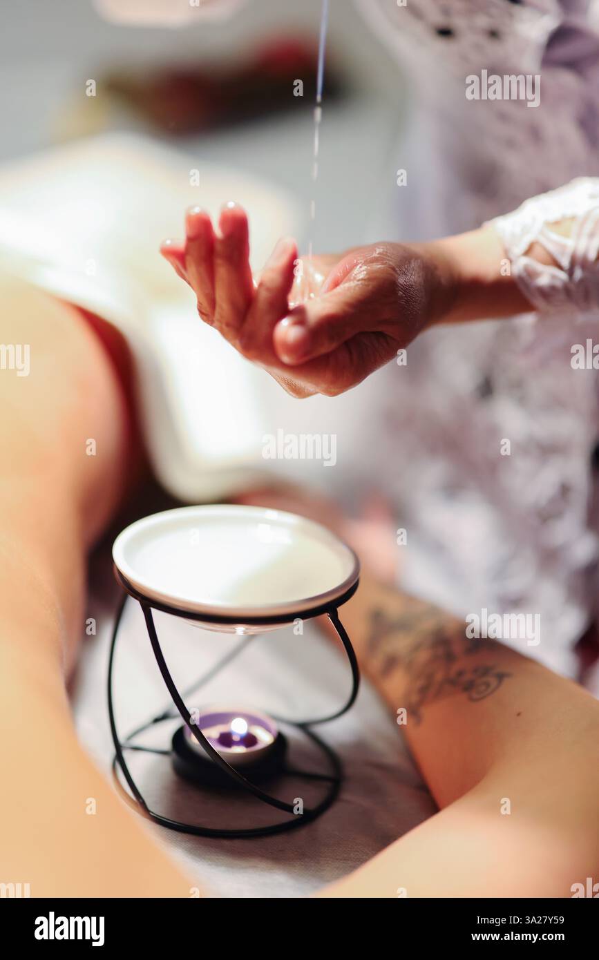 Aromathérapie. Femme recevant un massage du dos avec de l'huile dans le salon de spa, gros plan Banque D'Images