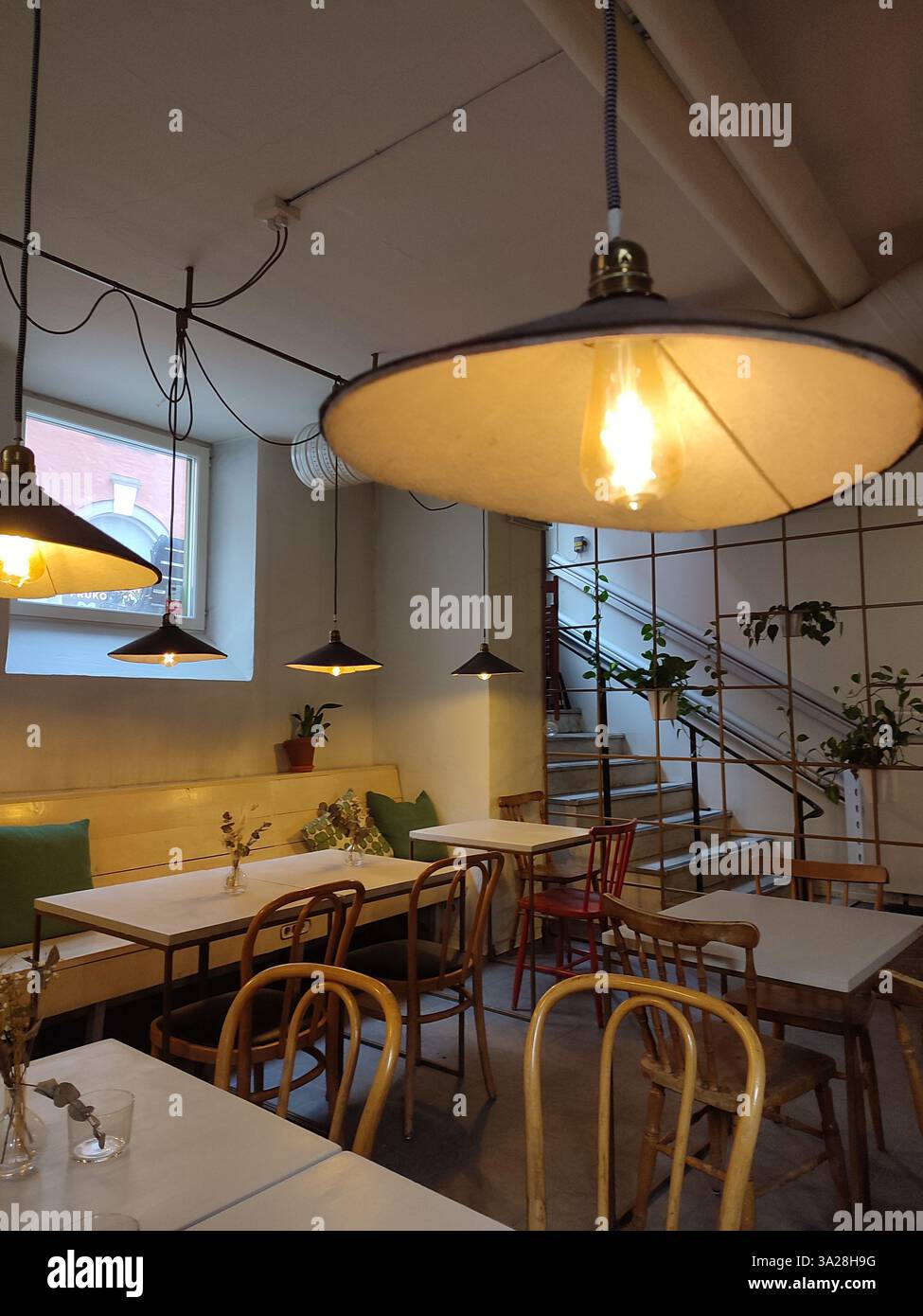 Intérieur de café de style scandinave avec éclairage chaleureux, chaises en bois et design minimaliste à Stockholm, Suède Banque D'Images