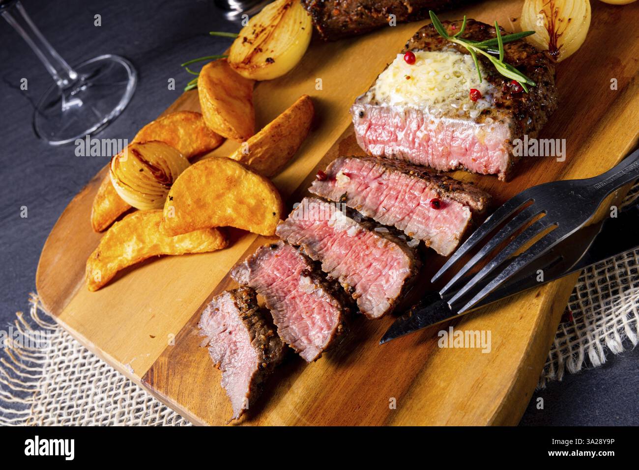 Steak de boeuf rustique moyen rare avec herbes et quartiers de pommes de terre Banque D'Images