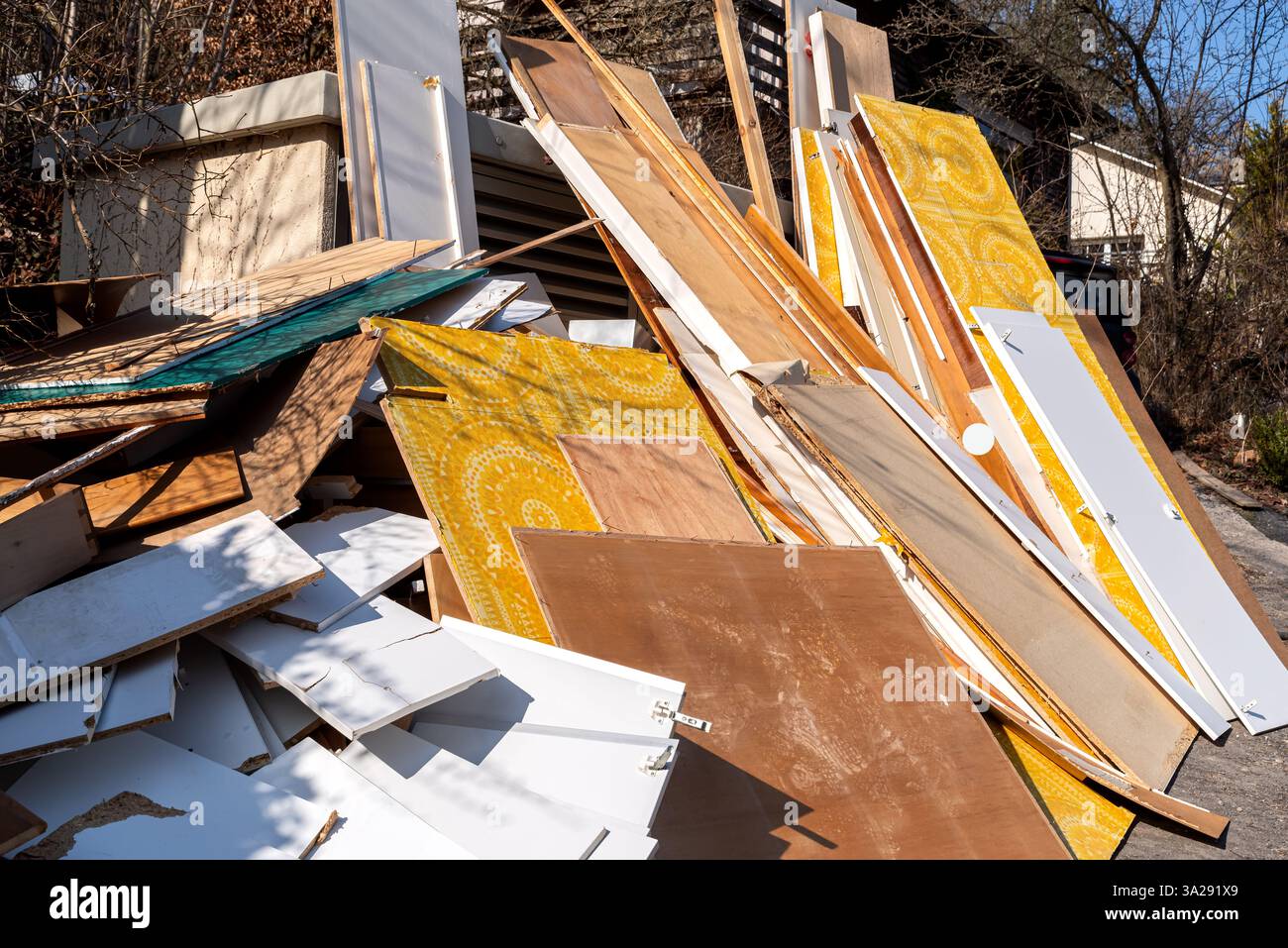 Une grande pile de pièces de meubles, de planches de bois et de portes jetées est empilée à l'extérieur sur un site de collecte. Banque D'Images