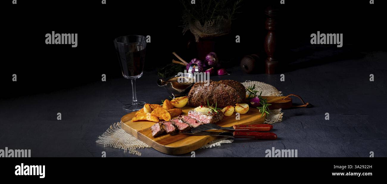 Steak de boeuf rustique moyen rare avec herbes et quartiers de pommes de terre Banque D'Images