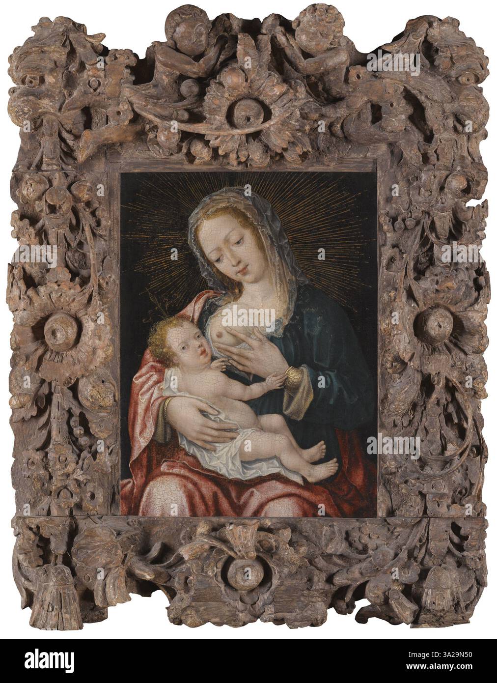 Cette représentation de la Vierge à l'enfant, attribuée à un disciple de Joos van Cleve, montre Marie tenant l'enfant Jésus. L'œuvre est caractéristique de l'iconographie chrétienne du XVIe siècle. Banque D'Images