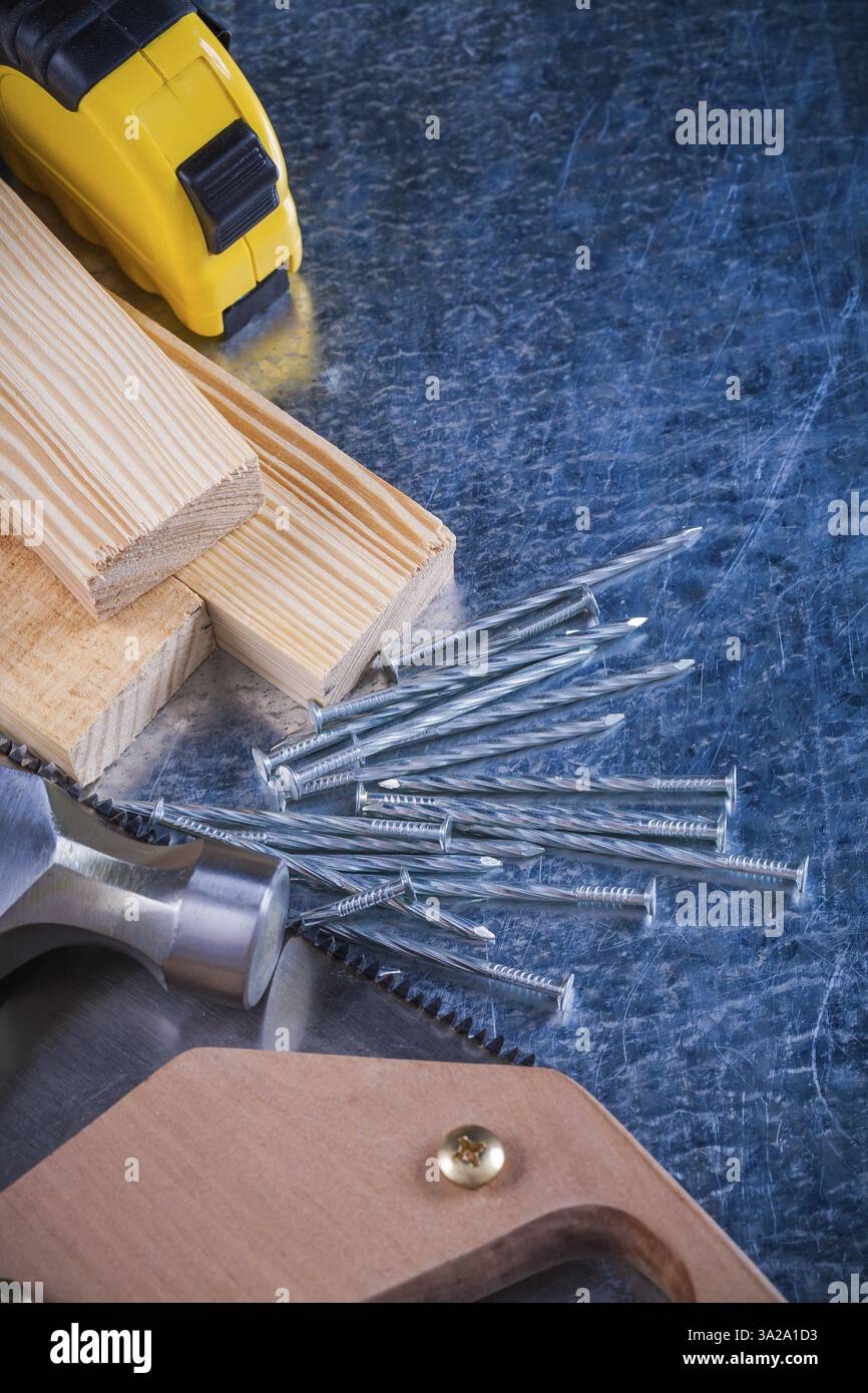 Ensemble de clous métalliques marteau briques en bois scie à main ruban-mètre sur le concept de construction de surface métallique rayée Banque D'Images