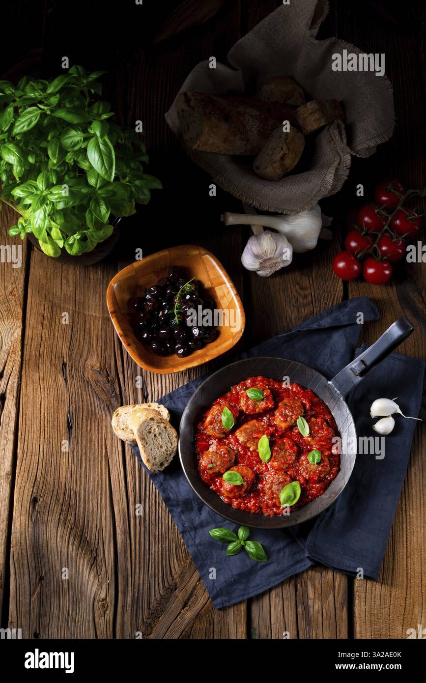 Mini boules cuites dans une sauce tomate avec basilic Banque D'Images