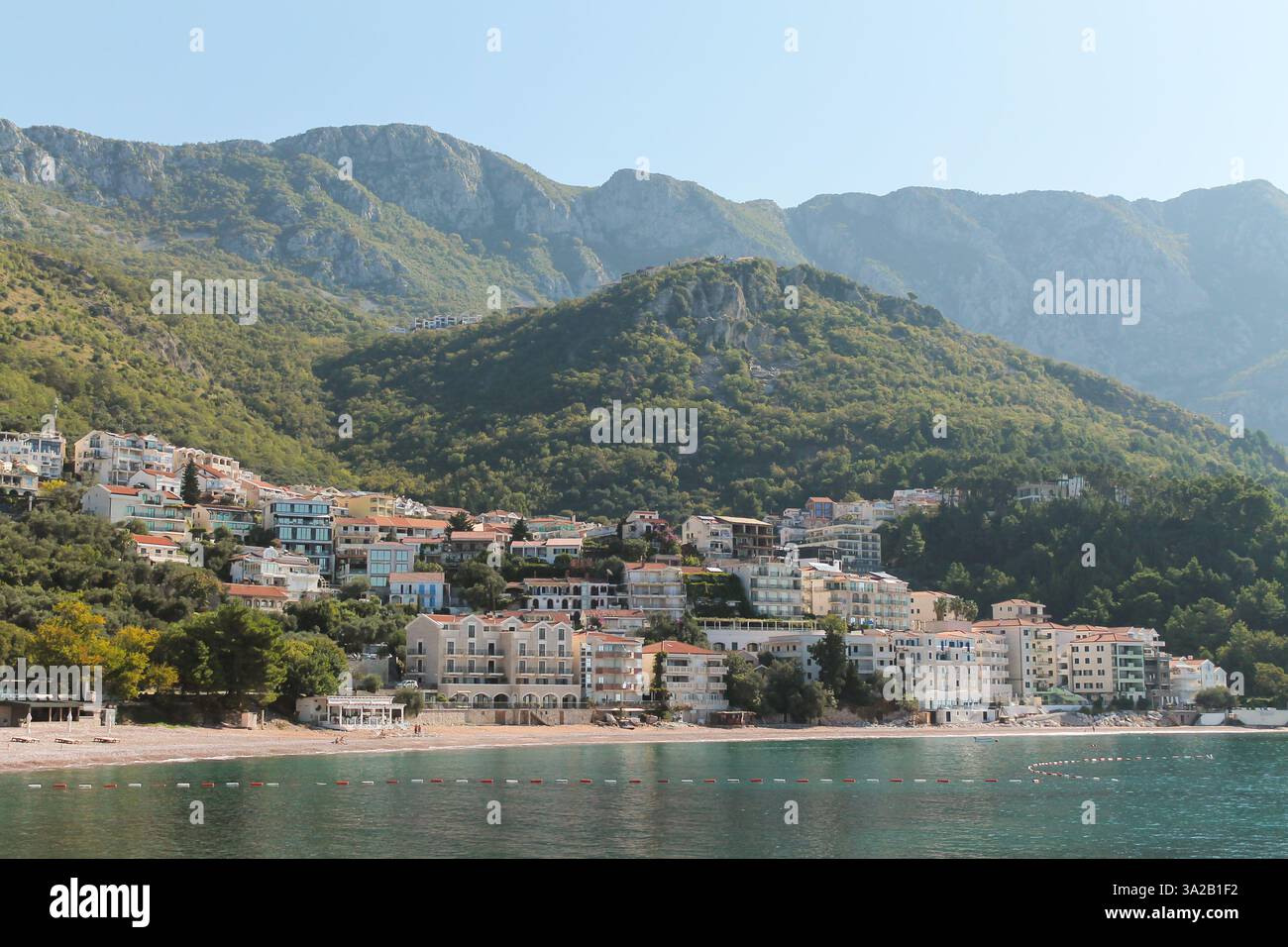 Une vue sur l'eau sur Sveti Stefan, Budva, une ville pittoresque sur la côte adriatique du Monténégro, avec de superbes montagnes en arrière-plan Banque D'Images