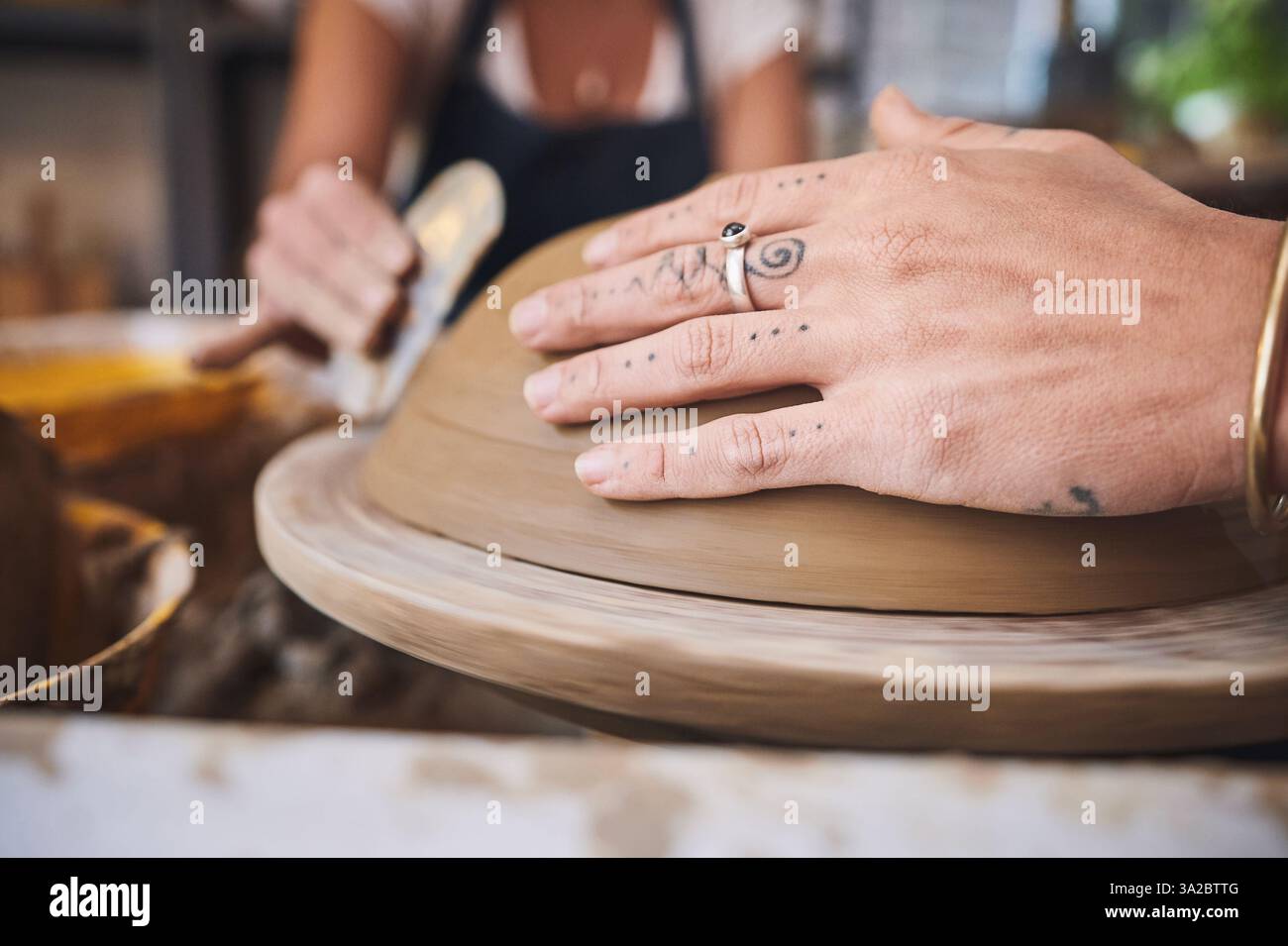 Personnes, mains et cours de poterie en studio, travaillant ensemble et sculptant de l'argile pour l'artisanat de céramique. Enseignement, équipement et aide à la leçon à Banque D'Images