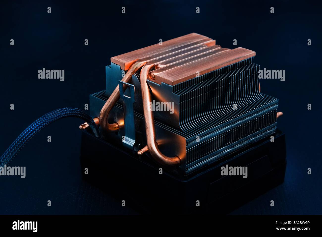 Dissipateur de chaleur en cuivre ou caloduc ou refroidisseur de processeur d'ordinateur avec radiateur et ventilateur sur fond sombre. Banque D'Images