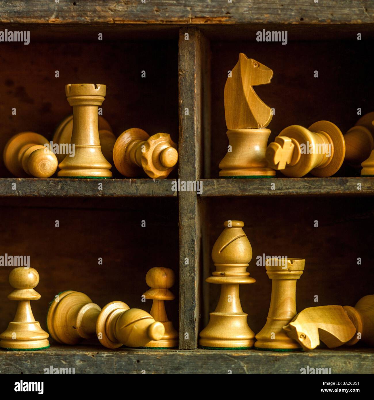 Pièces d'échecs en bois disposées dans une boîte vintage présentant des éléments de jeu stratégiques et de l'artisanat Banque D'Images