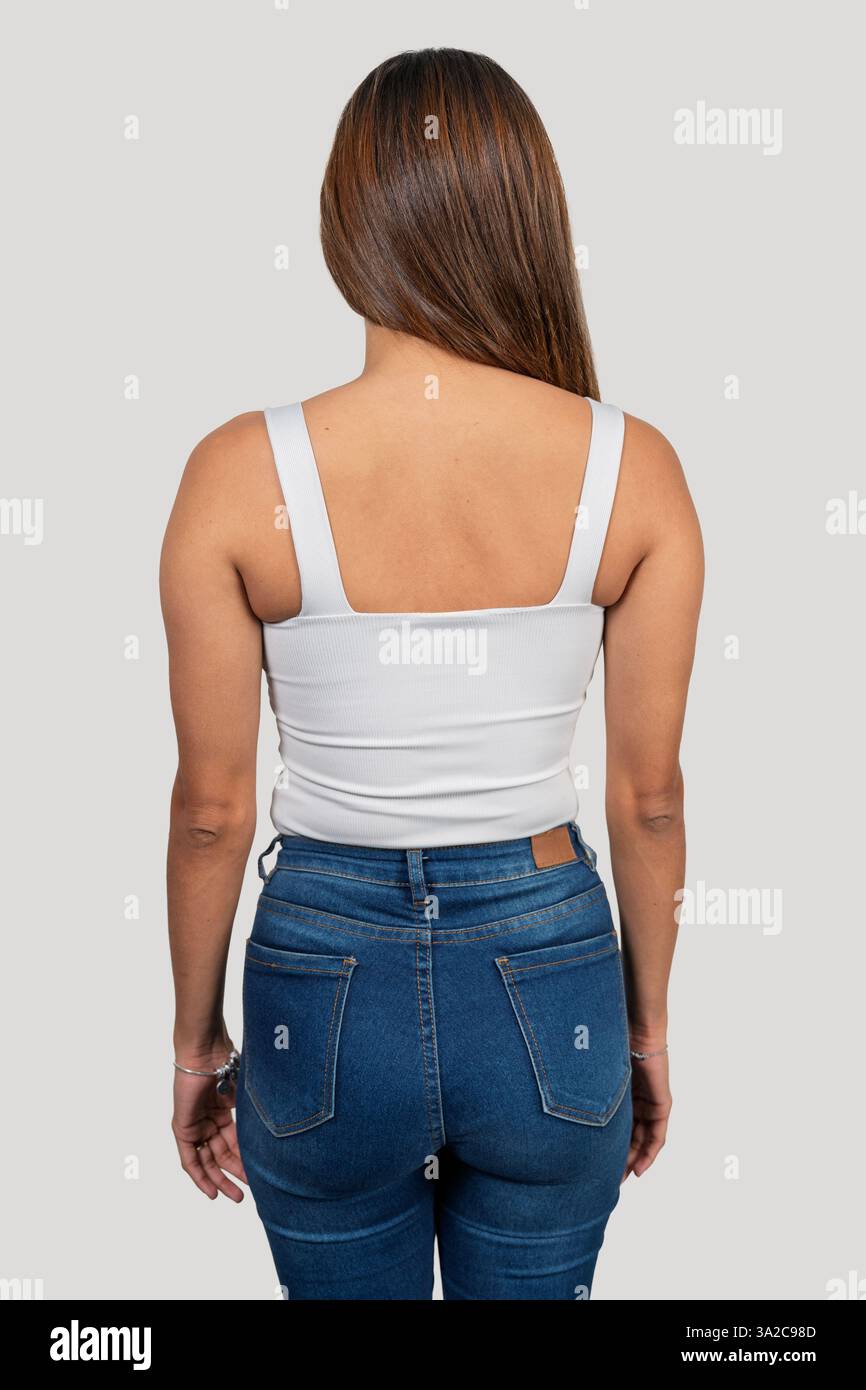 Photo studio d'une jeune femme portant un débardeur blanc et un Jean, mettant en valeur la vue arrière Banque D'Images