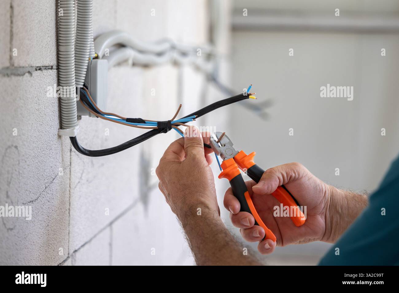 Électricien, réparateur, ingénieur électricien travaillant à l'installation d'une installation électrique sur un chantier de construction d'un nouveau bâtiment Banque D'Images