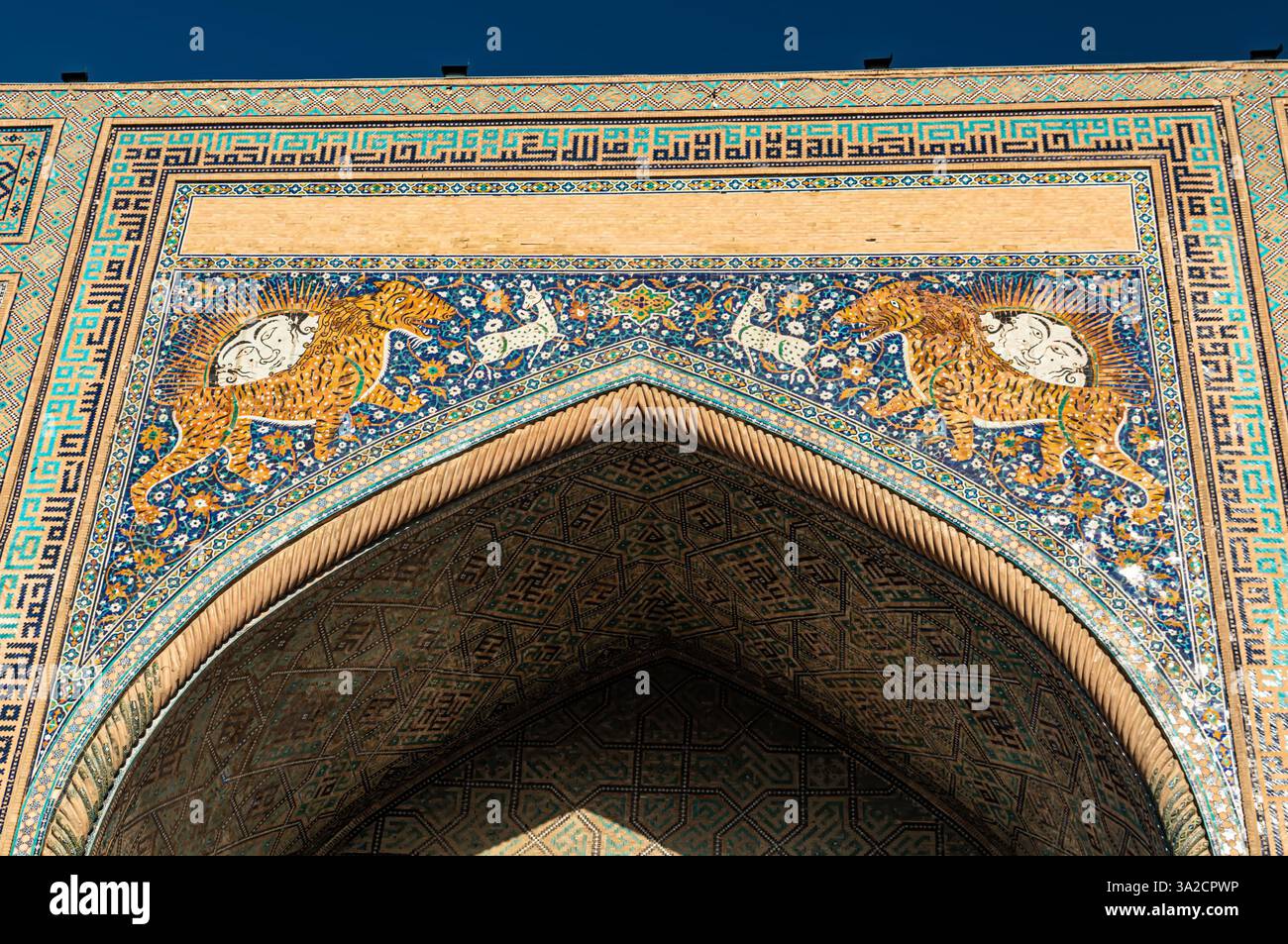Mosaïque avec le symbole de Samarkand, un lion tigre avec un soleil sur la façade de la madrasah Sherdor Banque D'Images