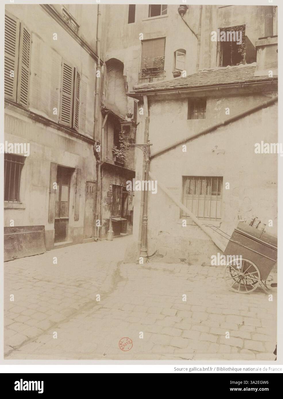 Eugène Atget capture l'arche d'entrée du cimetière Saint Paul, lieu de repos final de figures comme Rabelais, Mansart et l'homme au masque de fer, offrant un aperçu des cimetières historiques de Paris. Banque D'Images