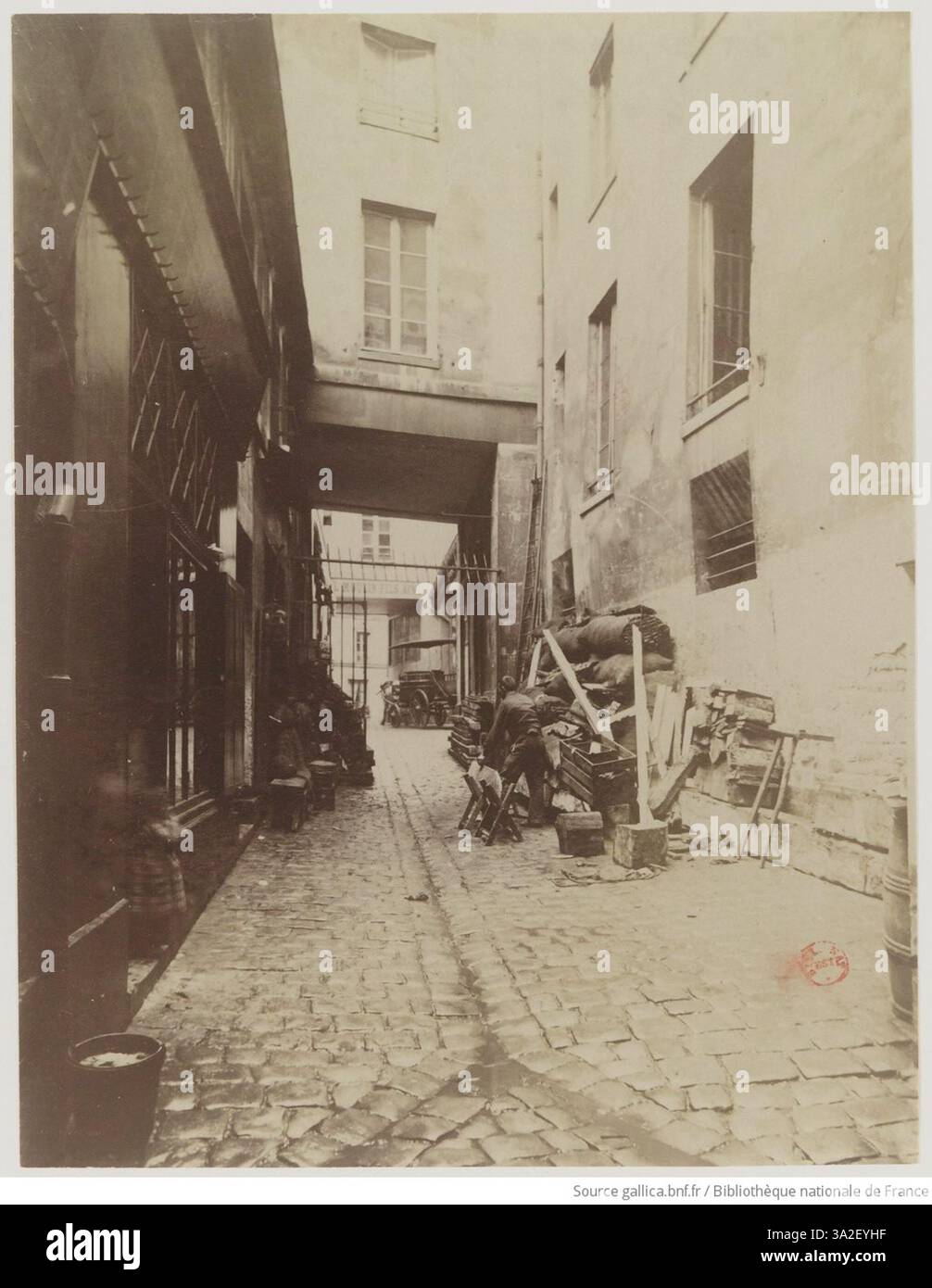 Cette photographie d’Eugène Atget montre le passage Charlemagne, en mettant l’accent sur les caractéristiques architecturales et le passage étroit typiques des rues commerçantes parisiennes. Banque D'Images