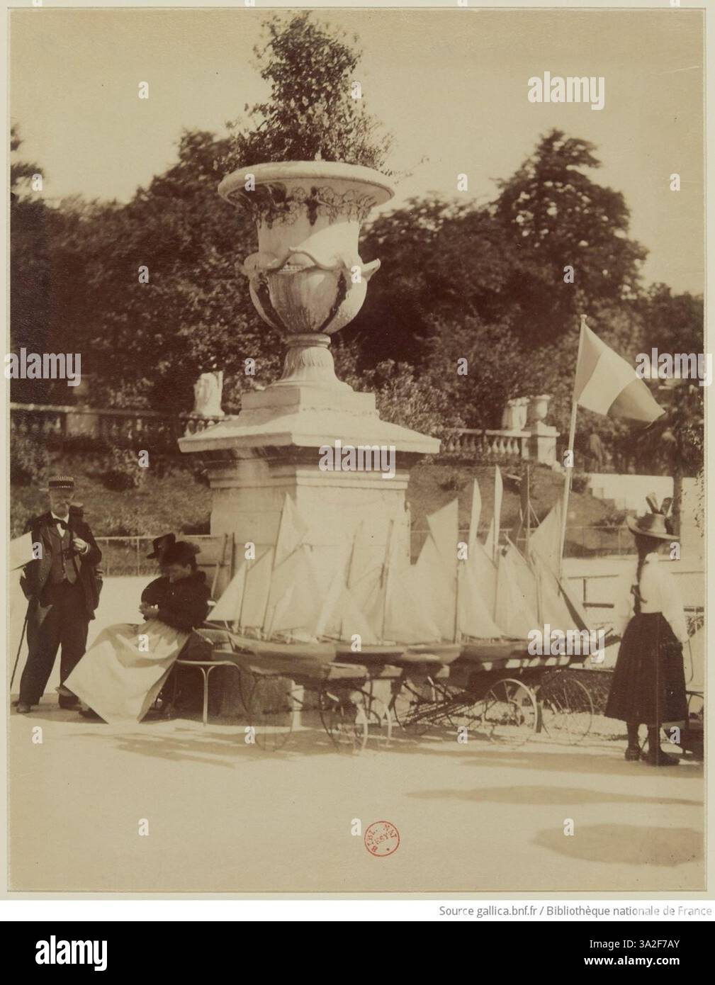 Cette photographie d’Eugène Atget montre un service de location de bateaux au jardin du Luxembourg à Paris. Prise au début du XXe siècle, elle met en lumière l’activité récréative populaire dans l’un des parcs les plus célèbres de Paris. Banque D'Images