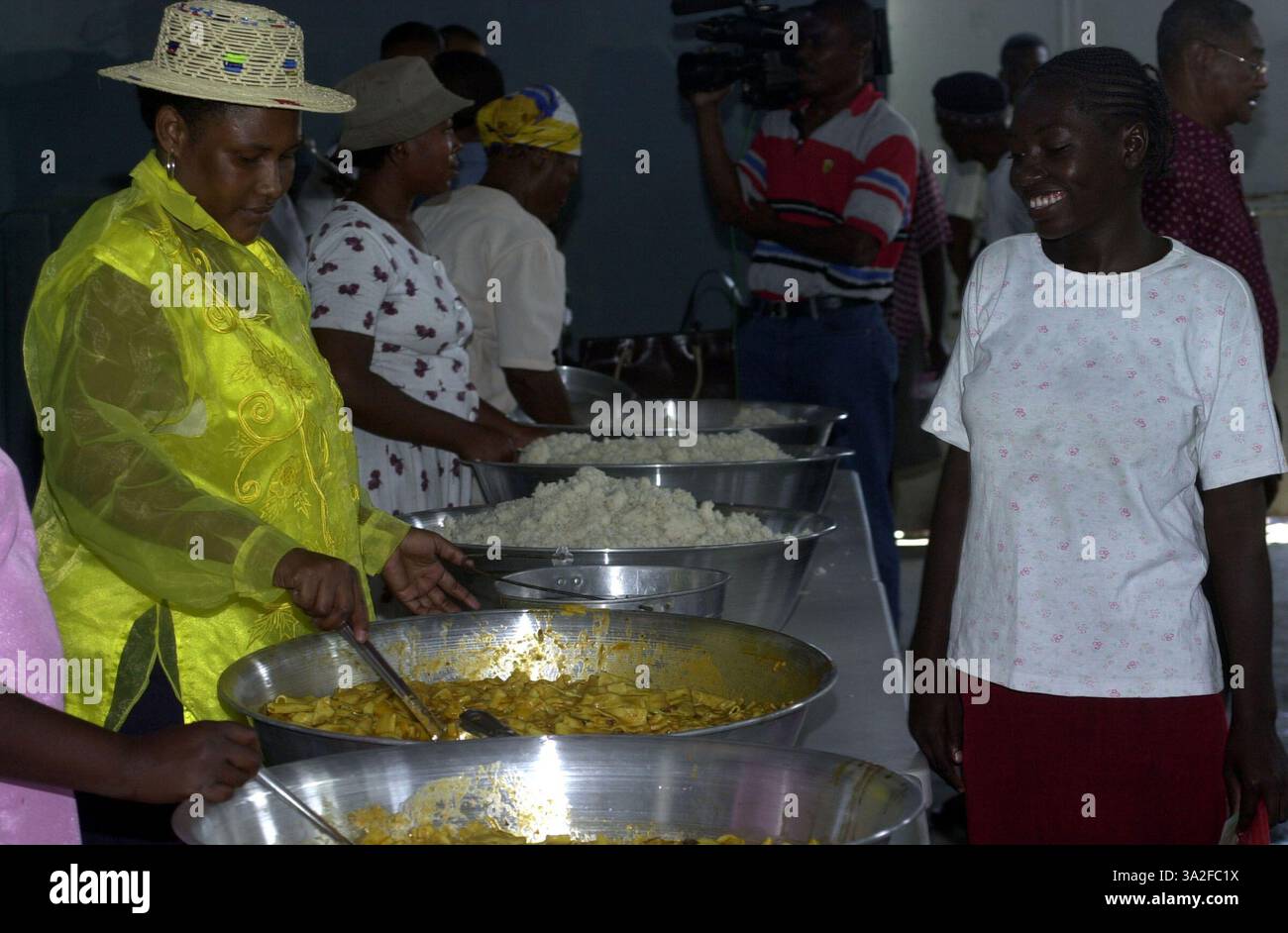 01 avril 2004 ; Cité Soleil, Haïti ; des bénévoles aident pendant une distribution de nourriture à l'école Food for the Poor dans le district de Cité Soleil ici. Les membres de la Force multinationale intérimaire - Haïti aident les organisations non gouvernementales à rétablir les programmes d'aide humanitaire qui étaient auparavant en place avant que les troubles civils n'éclatent. Banque D'Images