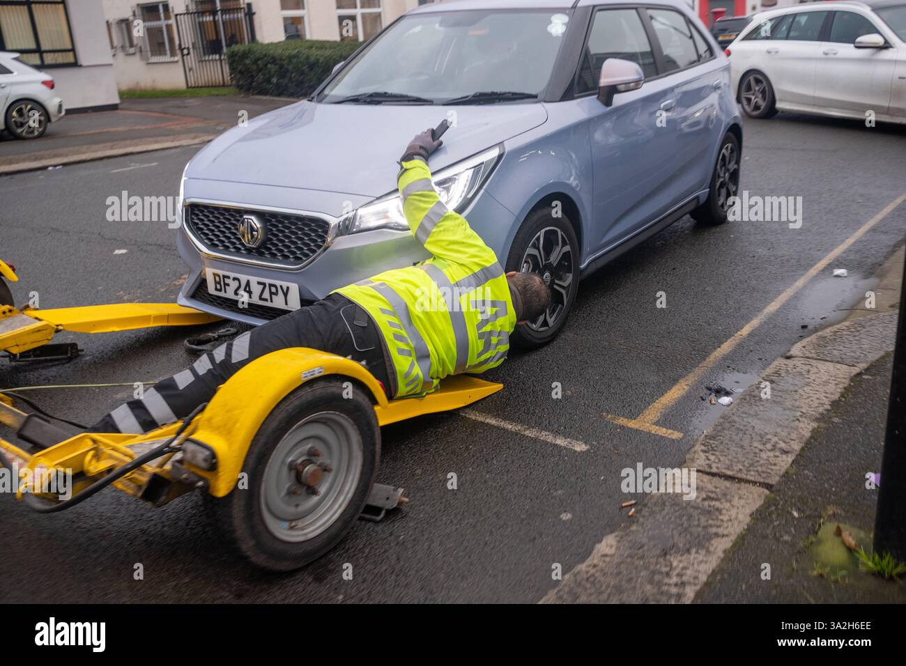 LONDRES - 10 FÉVRIER 2025 : AA technicien de dépannage routier s'occupe d'une voiture en panne Banque D'Images
