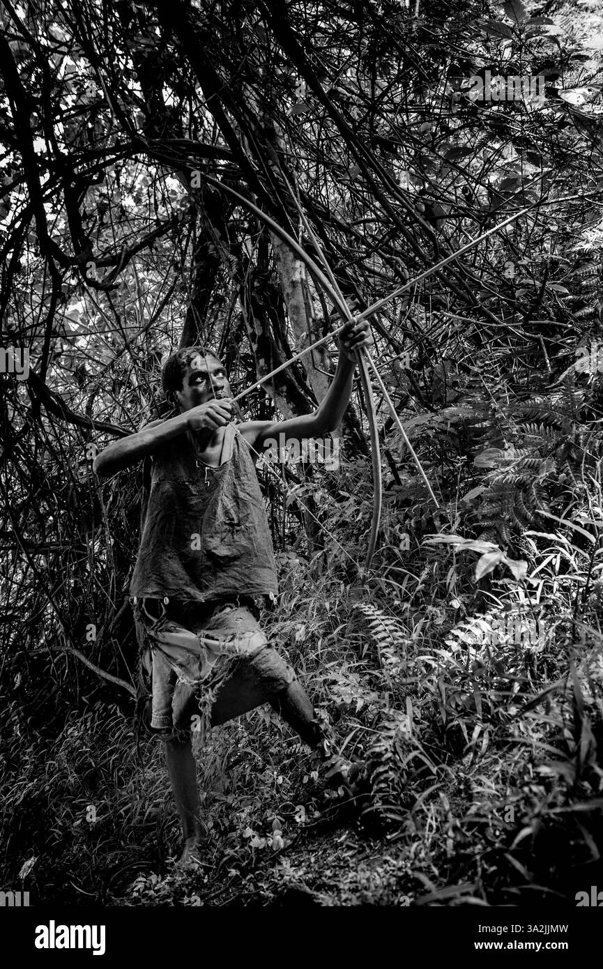5 mars 2014 - Ouganda - chasseur pygmée avec une flèche et un arc à la recherche de nourriture. Au cœur des riches forêts tropicales du sud-ouest de l'Ouganda, les pygmées Batwa indigènes ont partagé leur terrain tropical avec de majestueux gorilles de montagne pendant des milliers d'années. Certains anthropologues estiment que les tribus pygmées telles que les Batwa existent dans les forêts équatoriales d'Afrique depuis 60 000 ans ou plus. Le mode de vie des Batwa était antérieur à l'agriculture et à l'élevage ; ils étaient des chasseurs-cueilleurs qui dépendaient des ressources naturelles de la forêt pour leur subsistance. (Crédit image : © Peter Bauza/ZUMA Wire/ZUMAPRESS.com) Banque D'Images