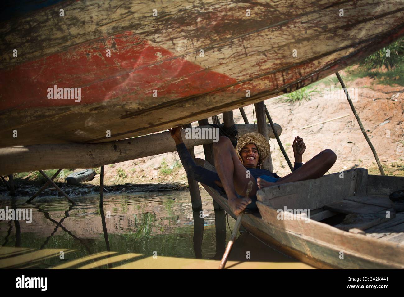 3 juin 2014 - Lac Tonle SAP, Cambodge - Un villageois d'un village flottant côtier le long du lac Tonle SAP, repose sous un bateau qui effectue des réparations en préparation des inondations de la saison des pluies. (Image de crédit : James MacDonald/ZUMA Wire/ZUMAPRESS.com) Banque D'Images