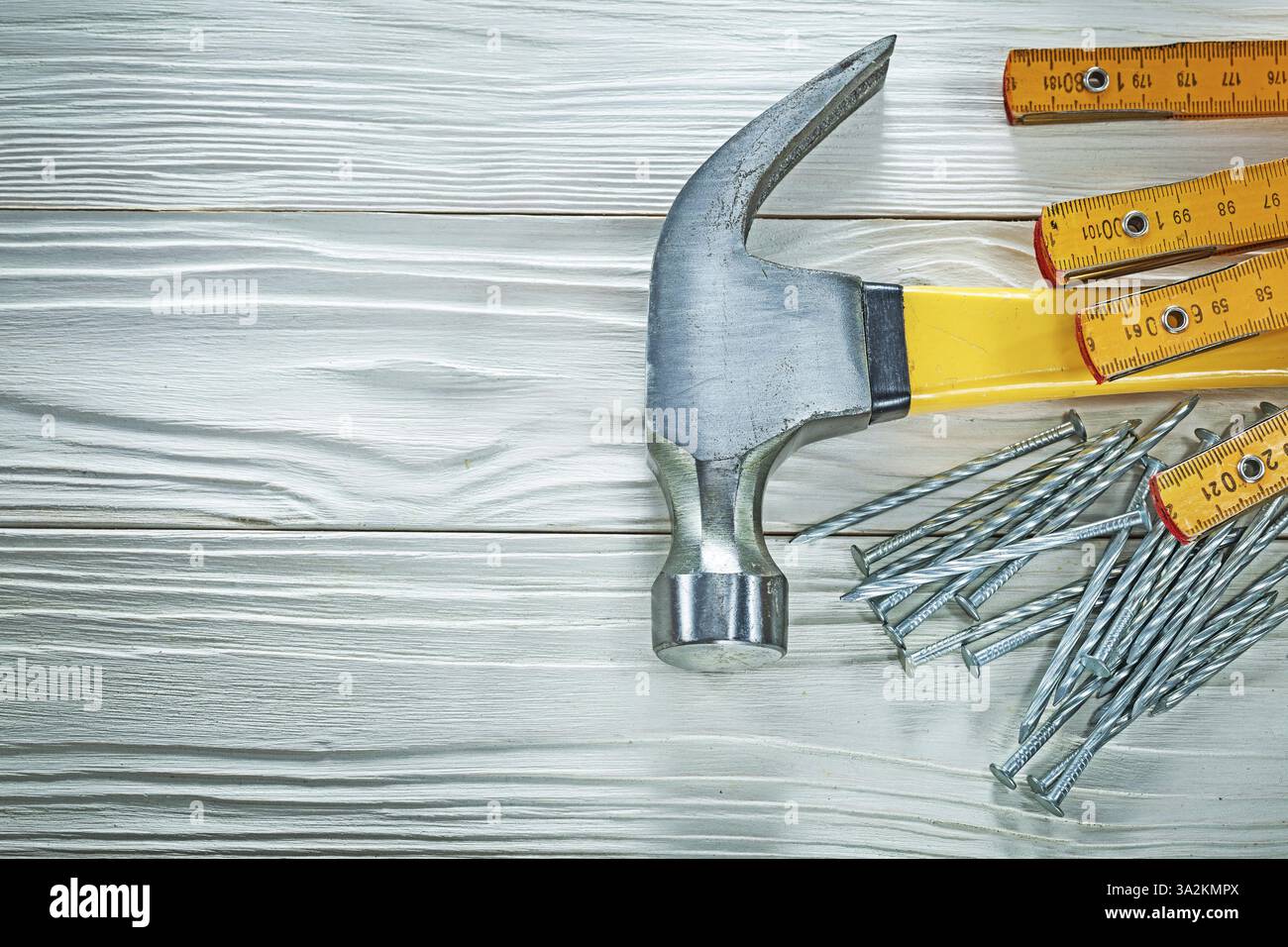 Marteau de pince de mètre en bois clous inoxydables sur planche de bois Banque D'Images