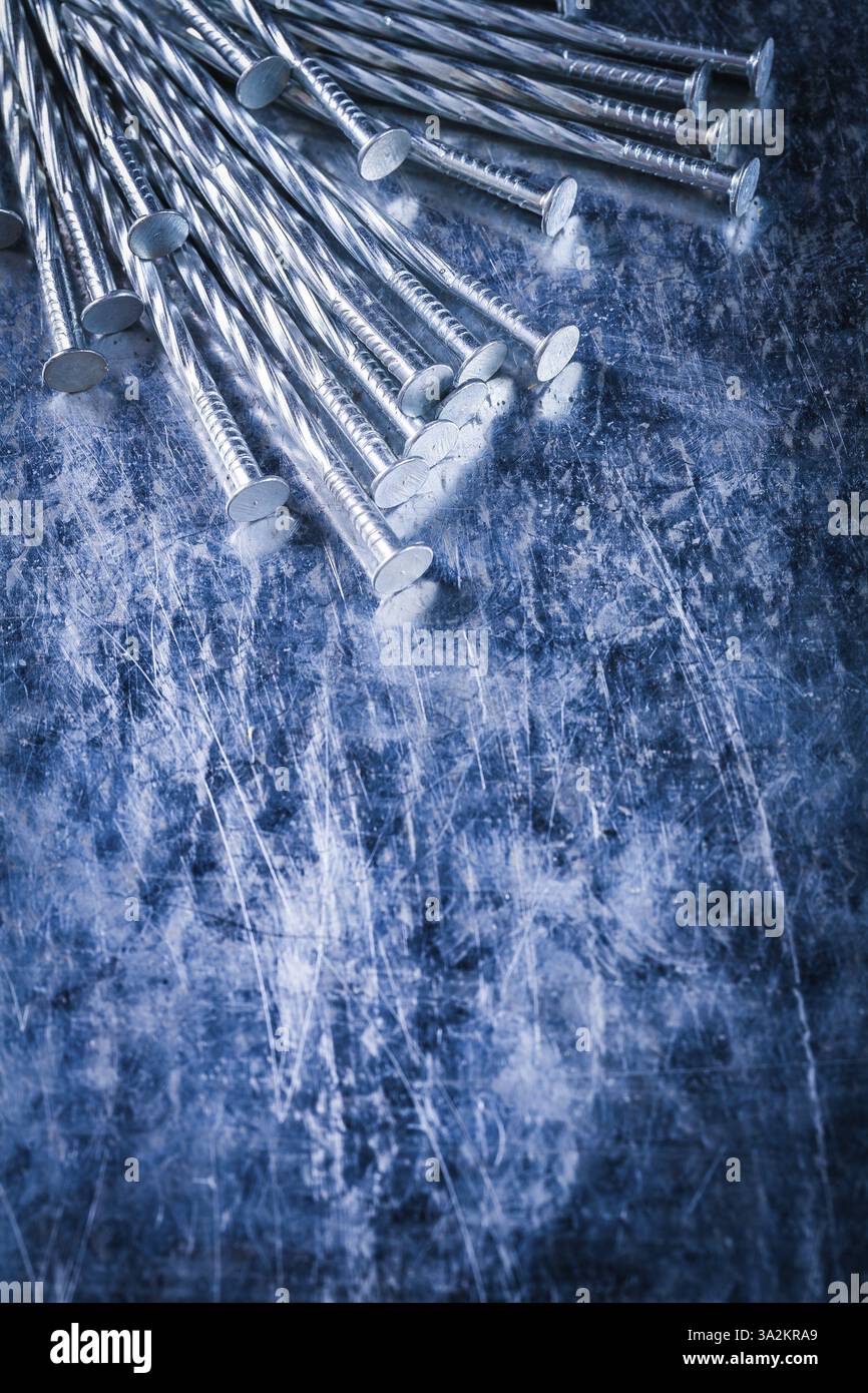 Clous de construction en acier inoxydable sur fond métallique rayé concept de construction d'image copyspace Banque D'Images