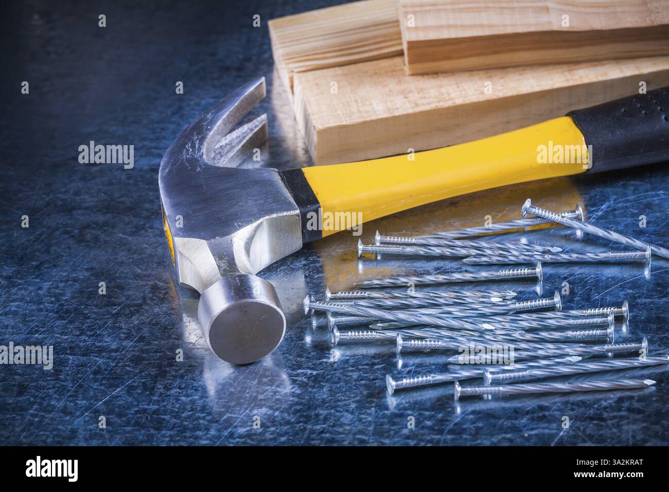 Marteau à griffes de clous inoxydables et briques en bois sur le concept de construction de fond métallique rayé Banque D'Images