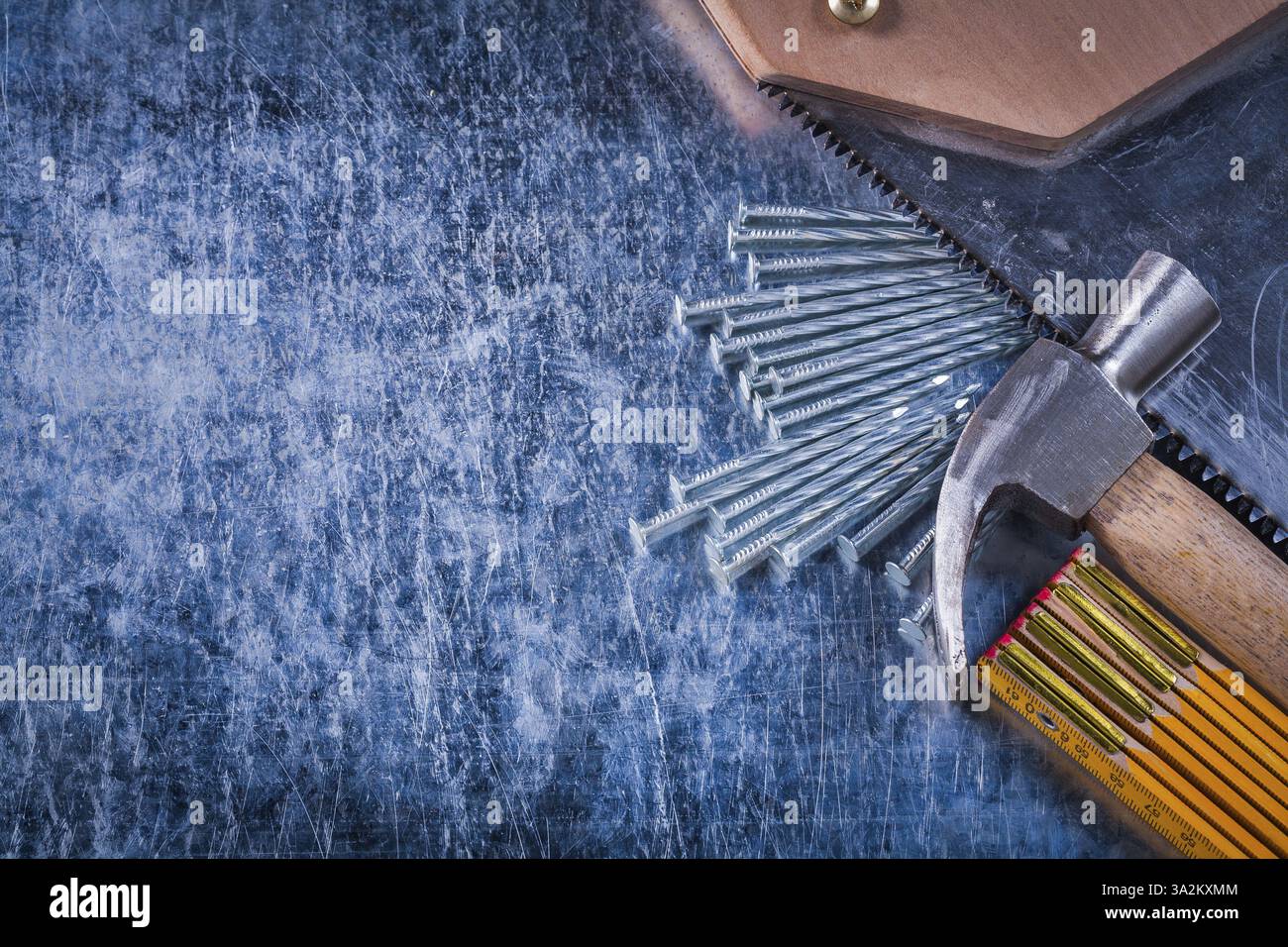 Ensemble de clous de scie à main mètre en bois et marteau à griffe sur le concept de construction de fond métallique rayé Banque D'Images