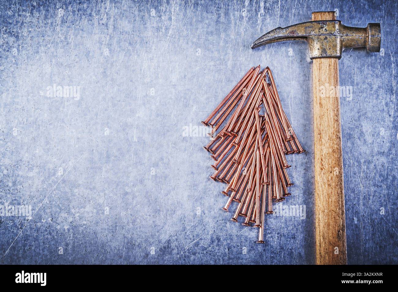Ensemble de clous de construction en laiton de marteau à griffes vintage sur fond métallique Banque D'Images
