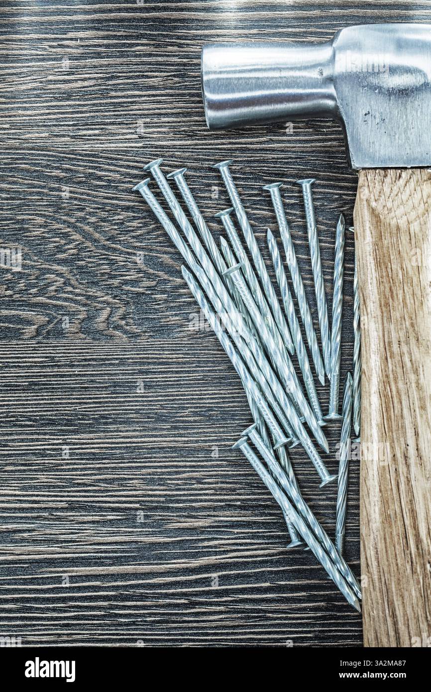 Marteau à griffes de clous de construction inoxydable sur planche de bois Banque D'Images