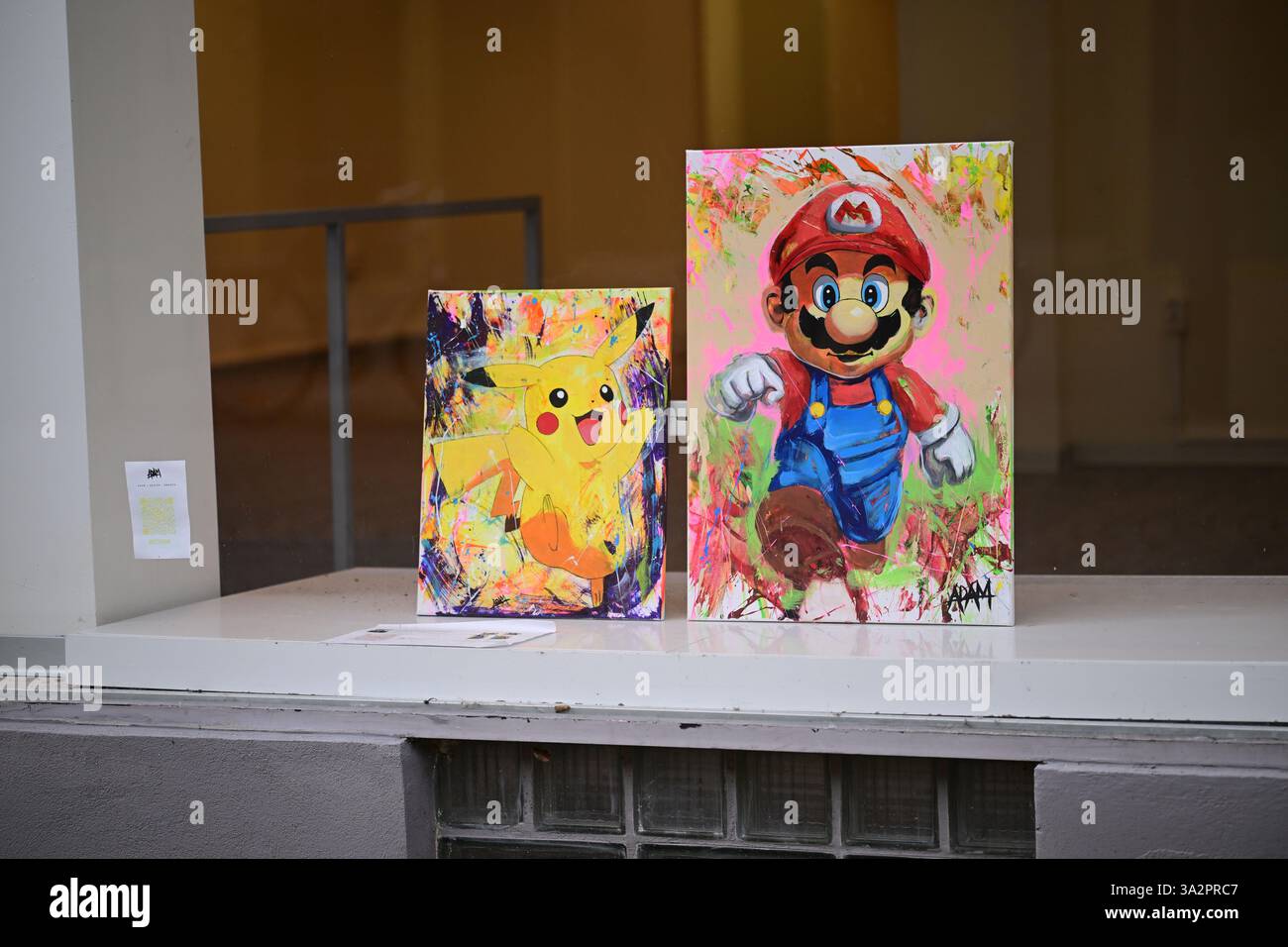 Kristianstad, Skåne, Suède. 13 mars 2025. Fenêtre avant de magasin pour une galerie d'art. Peintures de Pikachu et Super Mario. Banque D'Images Kristianstad, Skåne, Suède. 13 mars 2025. Fenêtre avant de magasin pour une galerie d'art. Peintures de Pikachu et Super Mario. Banque D'Images