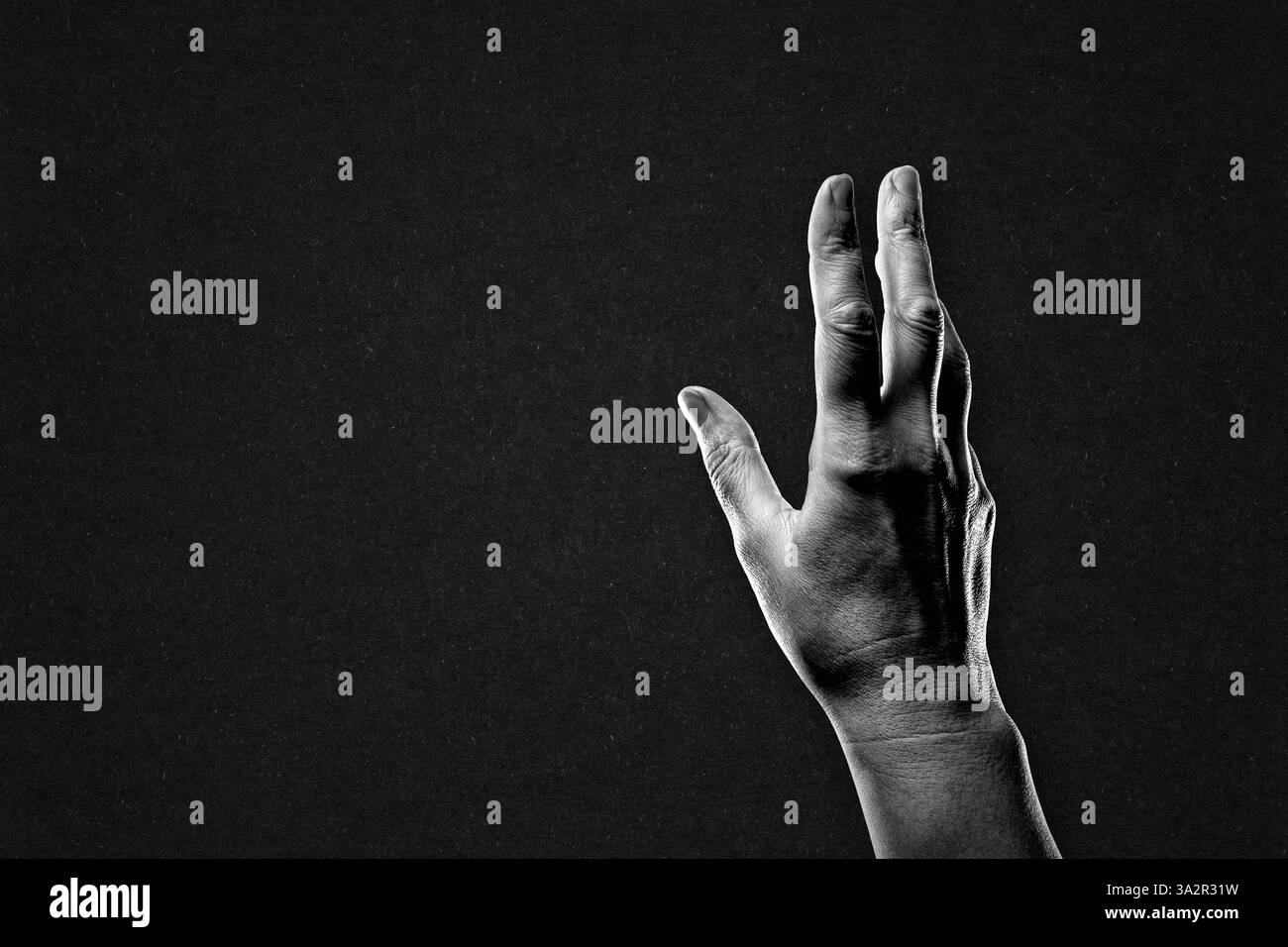 Main atteignant signe en noir et blanc sur fond de papier texturé, espace de copie Banque D'Images