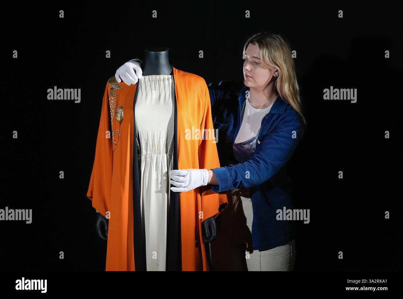 SOUS EMBARGO JUSQU'au 0001 MARDI 8 OCTOBRE Un employé de Propstore ajuste le costume de Cléopâtre d'Elizabeth Taylor (estimé à £10 000 - £20,000) du film de 1963 'Cléopâtre' lors d'une visite photo au Propstore de Rickmansworth, Hertfordshire, avant leur vente aux enchères en direct de souvenirs de divertissement qui se déroulera sur quatre jours à partir du 14 novembre. Date de la photo : jeudi 3 octobre 2024. Banque D'Images