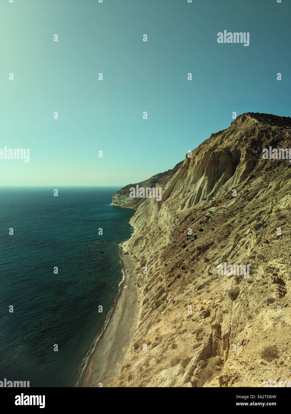 La côte accidentée du Cap Aspro est vue à travers des lunettes de soleil teintées, mêlant falaises ensoleillées à une mer Méditerranée sombre. - Image de stock capturée avec un smartphone