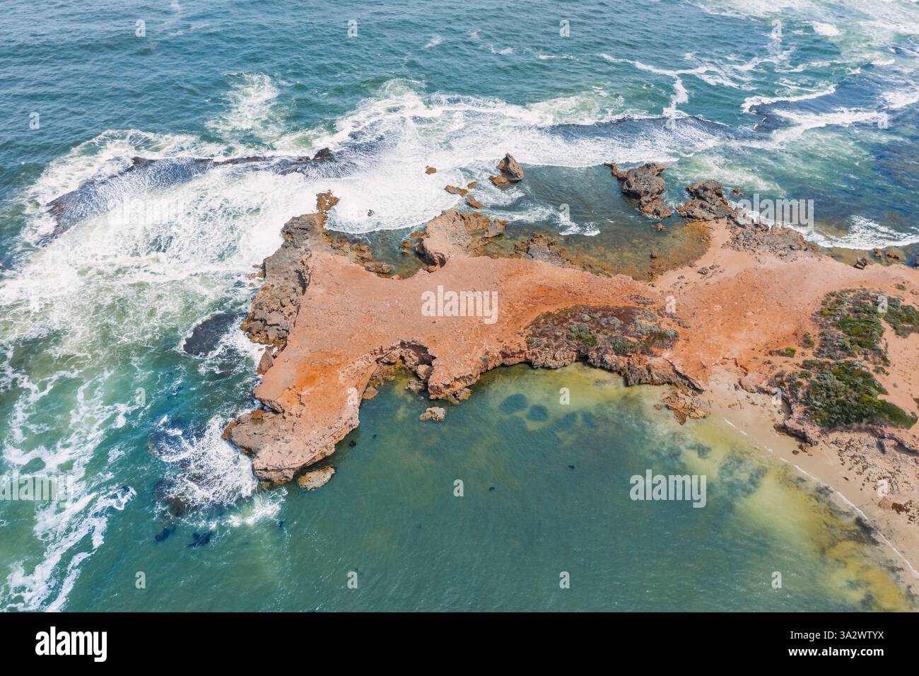 Vue aérienne d'un plateau côtier érodé entouré de vagues à Beachport sur la côte calcaire en Australie méridionale. Banque D'Images