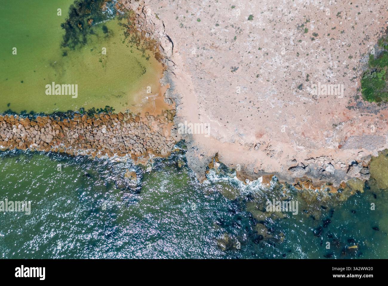 Vue aérienne d'un brise-lames rocheux menant à une île côtière à Beachport sur la Limestone Coast en Australie méridionale. Banque D'Images