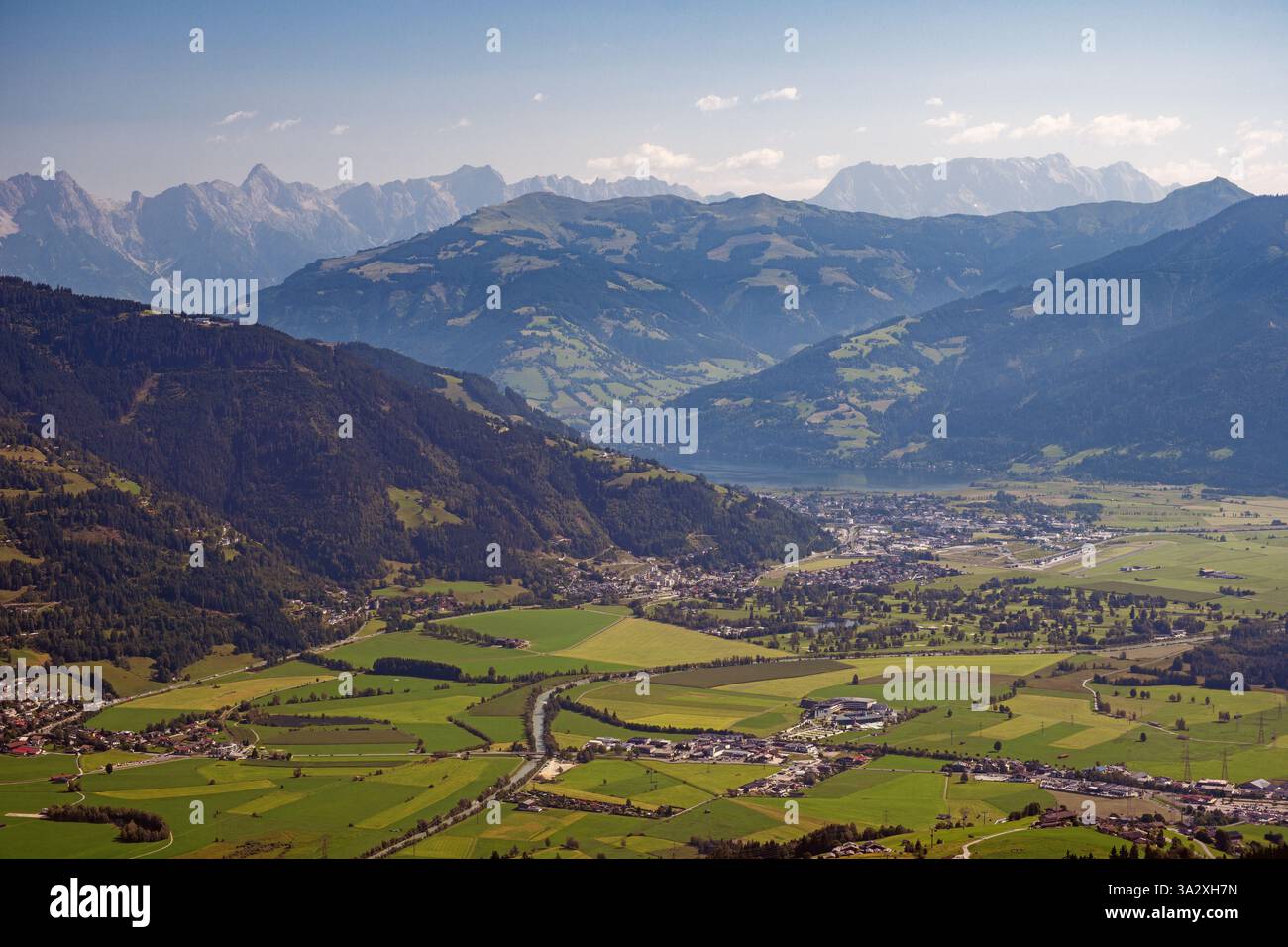 Vue aérienne de la ville de Kaprun dans le district de Zell am See, province de Salzbourg, Autriche. Champs verdoyants et hauts sommets montagneux. Banque D'Images Vue aérienne de la ville de Kaprun dans le district de Zell am See, province de Salzbourg, Autriche. Champs verdoyants et hauts sommets montagneux. Banque D'Images