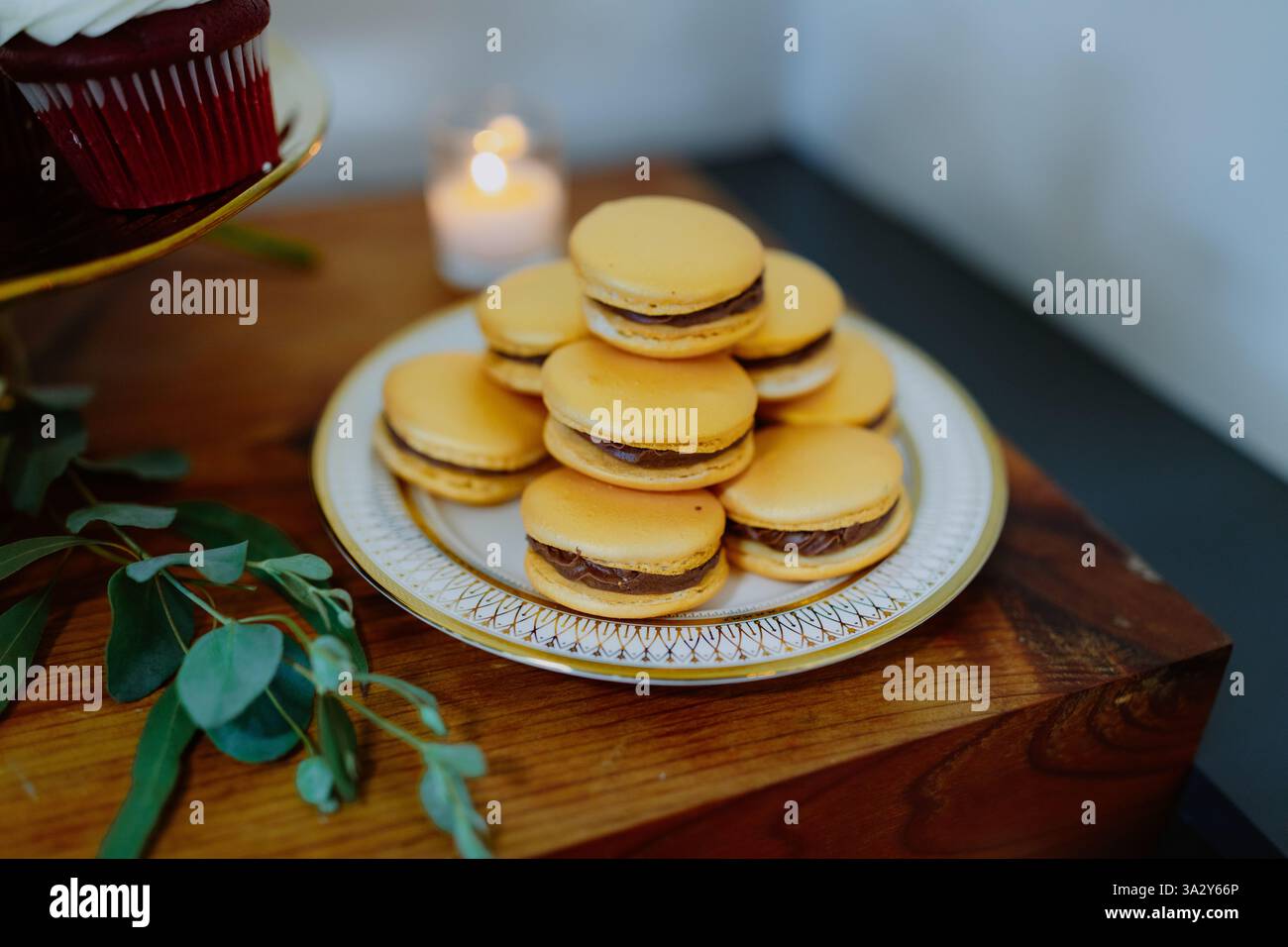 Élégante table à desserts décorée de macarons, de cupcakes et de chandelles Banque D'Images