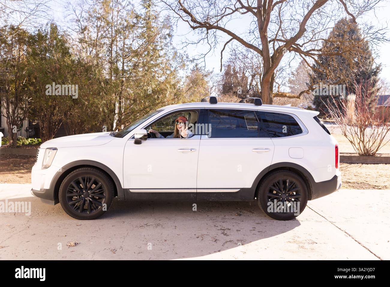 Une femme dans un SUV fait clignoter un signe de paix en conduisant Banque D'Images
