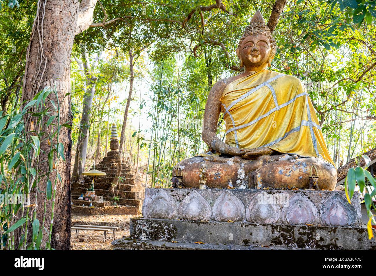 Situé sous une canopée d'arbres, monuments religieux sont dispersés, dans les collines, utilisés par les villageois locaux, parmi le paysage de forêt tropicale. Banque D'Images