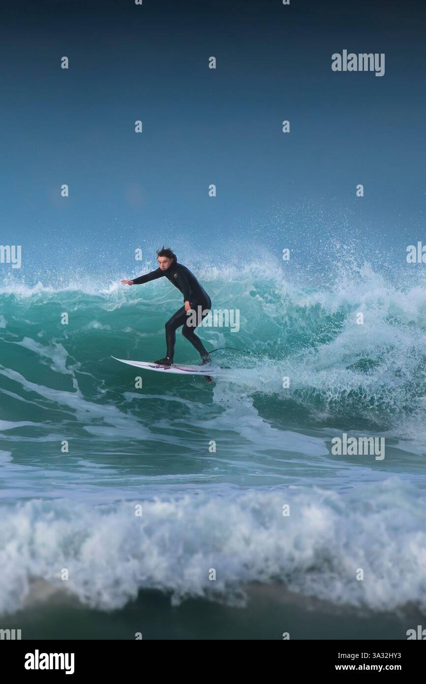 Un surfeur qui fait une vague à Fistral à Newquay, en Cornouailles, au Royaume-Uni. Banque D'Images