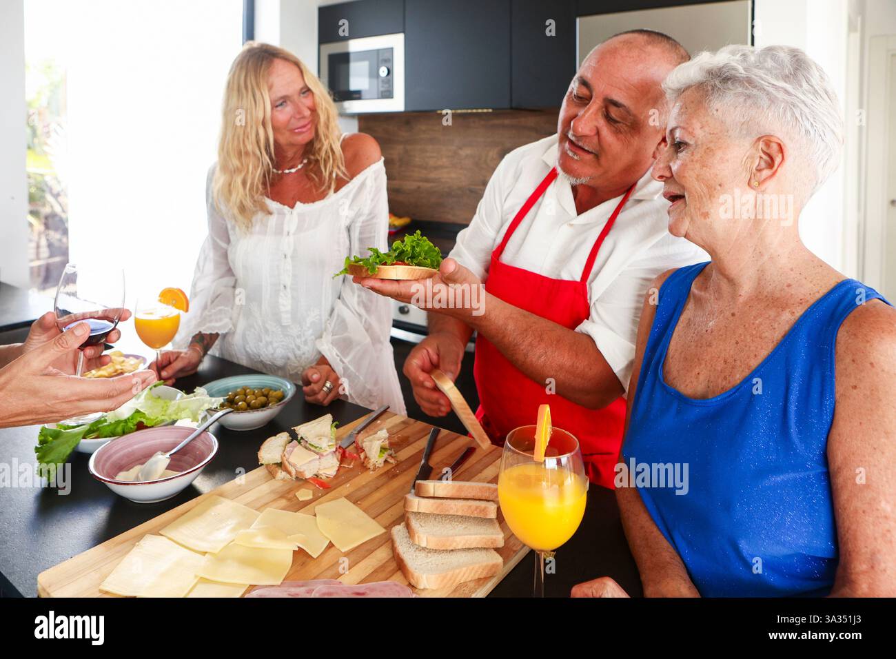 Les aînés joyeux se réunissent lors d'une fête de cuisine animée, partageant des histoires et des rires tout en s'adonnant à la préparation des aliments. Le réglage serein bourdonne avec liv Banque D'Images