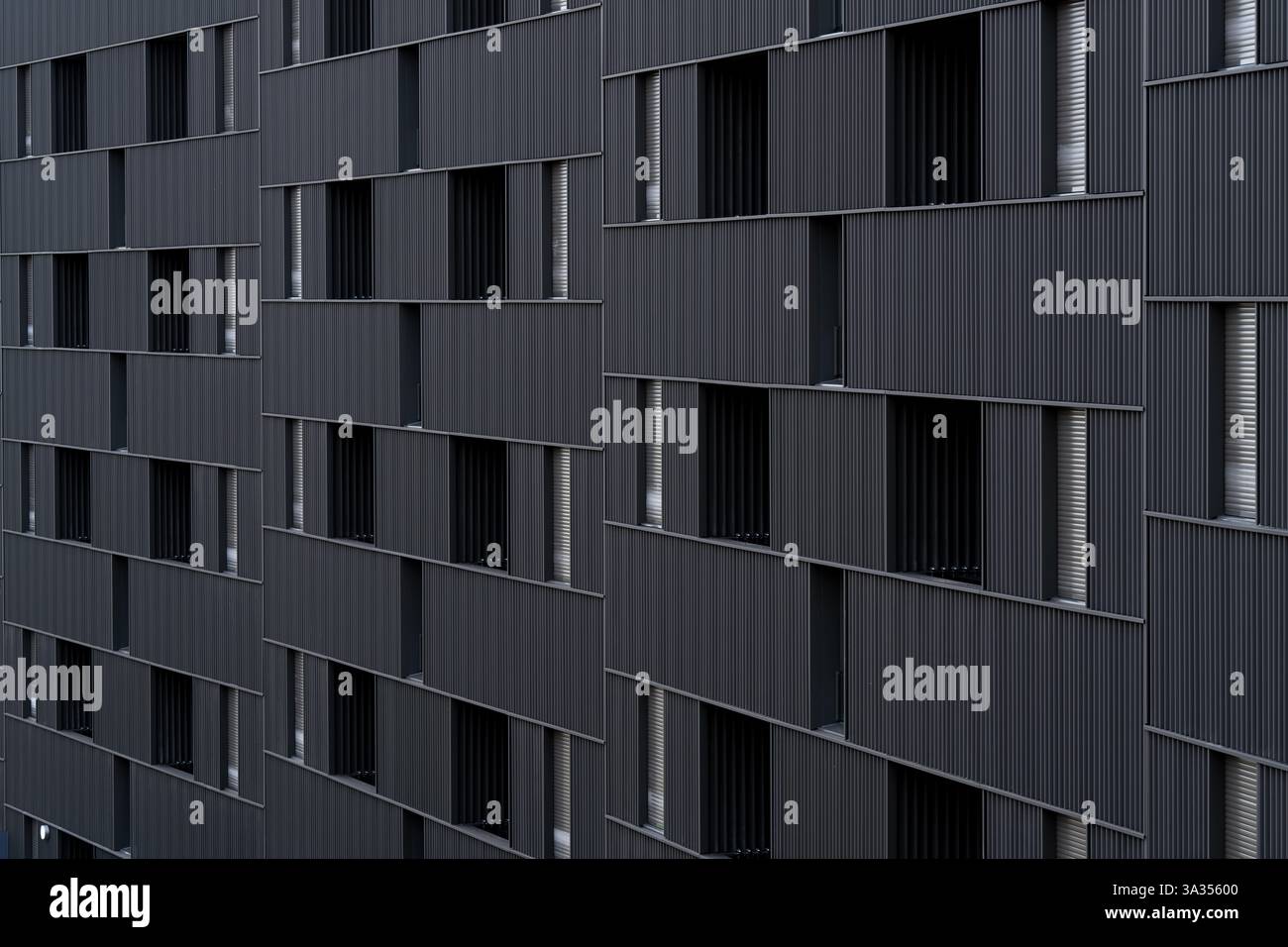 Bâtiment moderne présentant un style architectural distinct et durable avec des ouvertures de fenêtres alignées verticalement et répétées en forme de portail. Les emphas de conception Banque D'Images